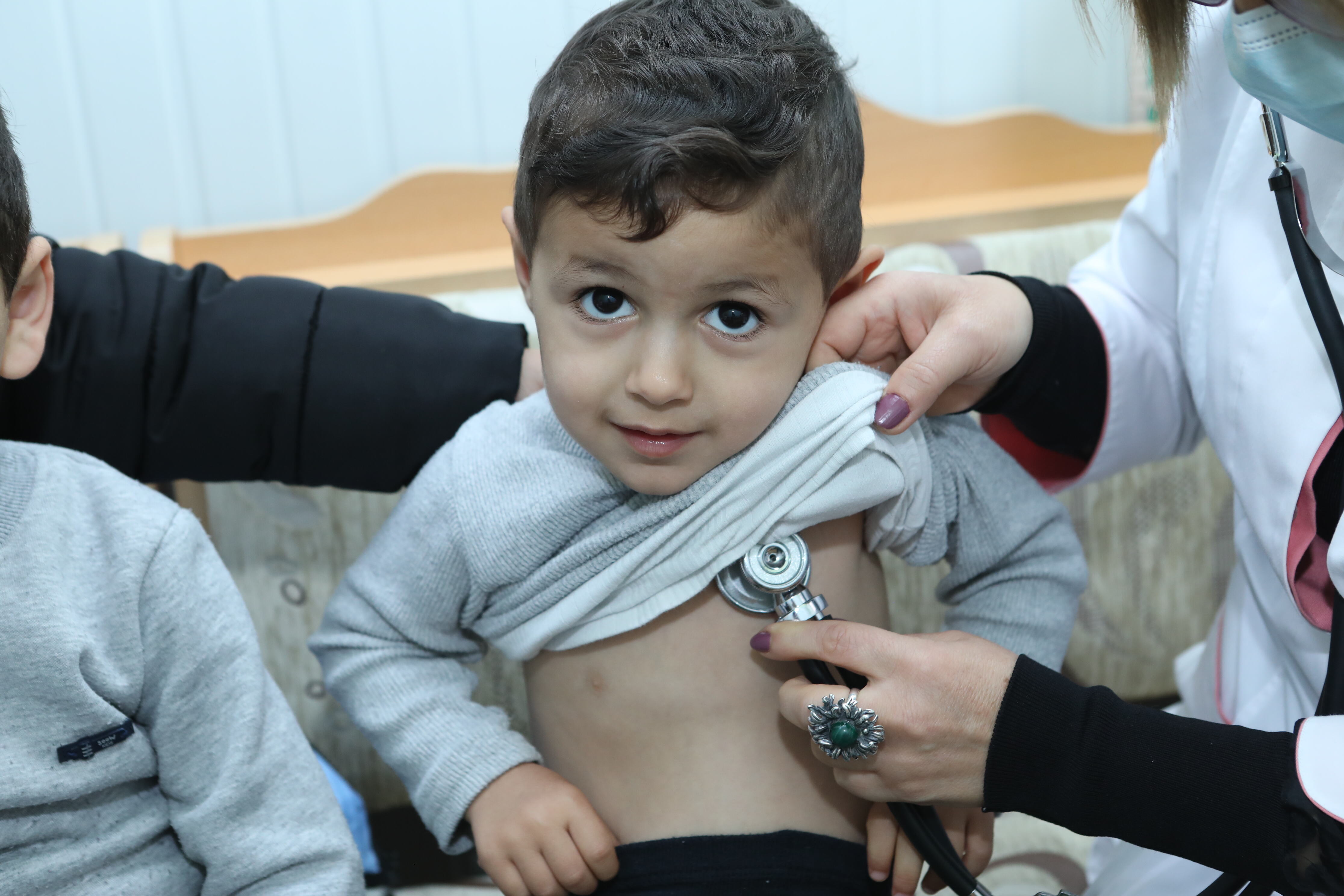 A pediatrician is checking the boy's lungs in a polyclinic in Tsaghkadzor.
