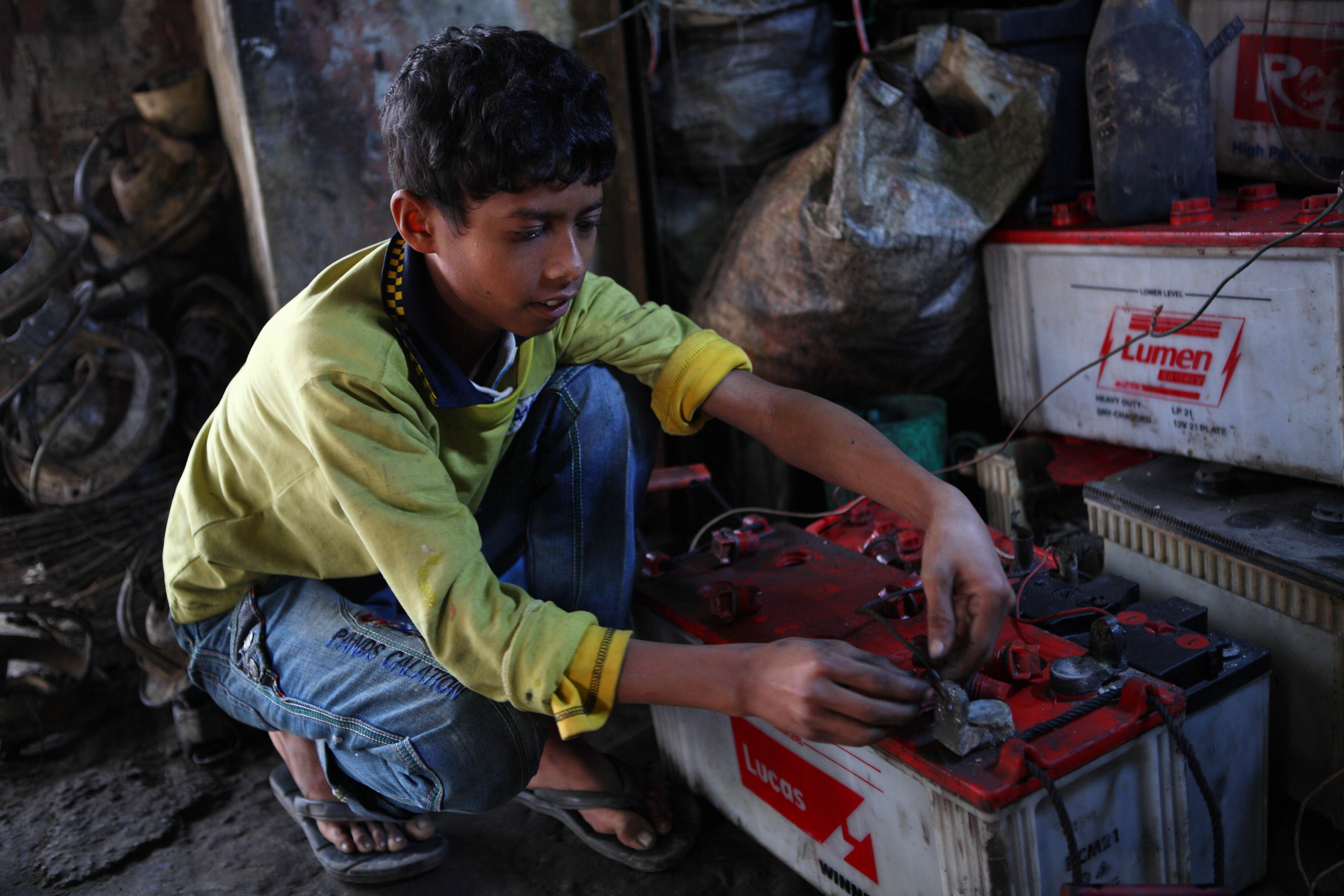 Al Amin, 10, works at a garage where he repairs batteries near the Tangail New Bus Stand on 1 February 2014.