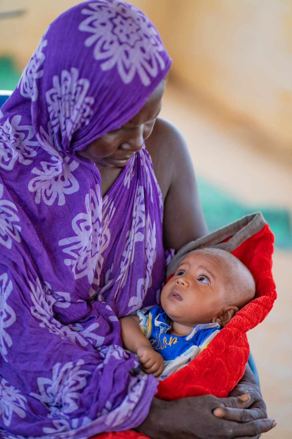 A mother with her child at the mobile clinic offering multiple services (vaccination, detection and follow-up of malnutrition cases, prenatal consultation, detection and follow-up of malaria cases, etc.) at the BAWA site for displaced people. Here, in a tent used as a waiting room for mobile clinic services. Nearly 3,000 displaced people, more than half of whom are children, have fled violence, conflict and/or food insecurity to find refuge at this Bawa IDP site.