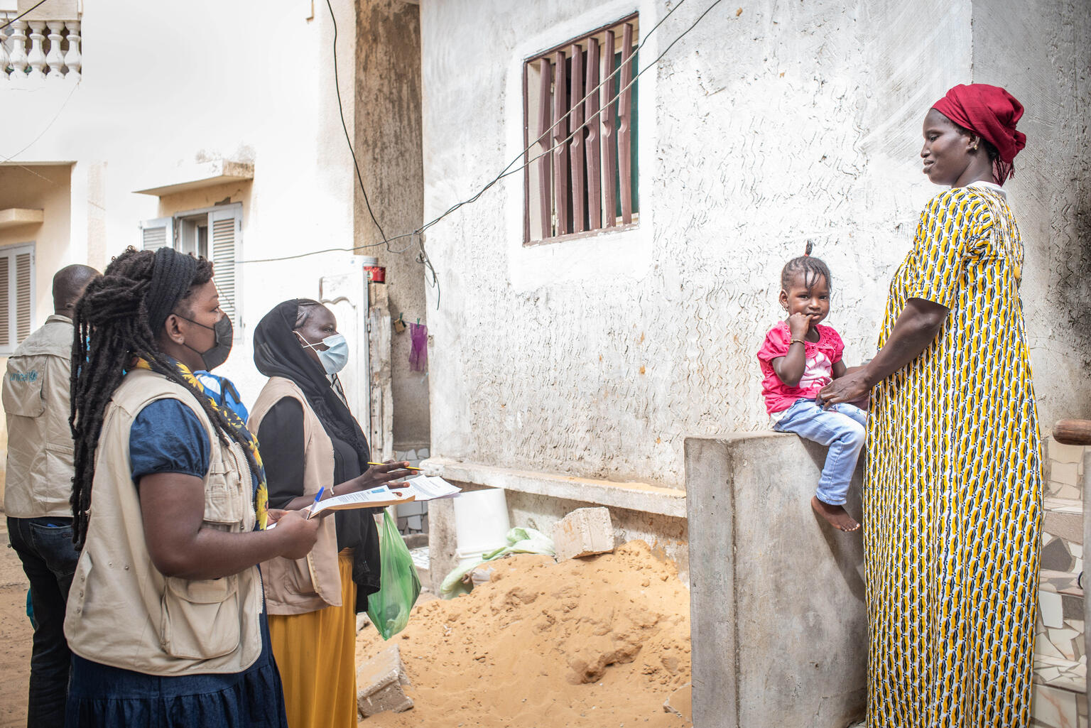 Social health workers Marie Astou Ndiaye and Nfeye Sarata Ndiaye, and UNICEF staff members, on door-to-door household visits to speak with parents and caregivers about polio, and vaccinate their children during a polio vaccination campaign on 18 December 2021.