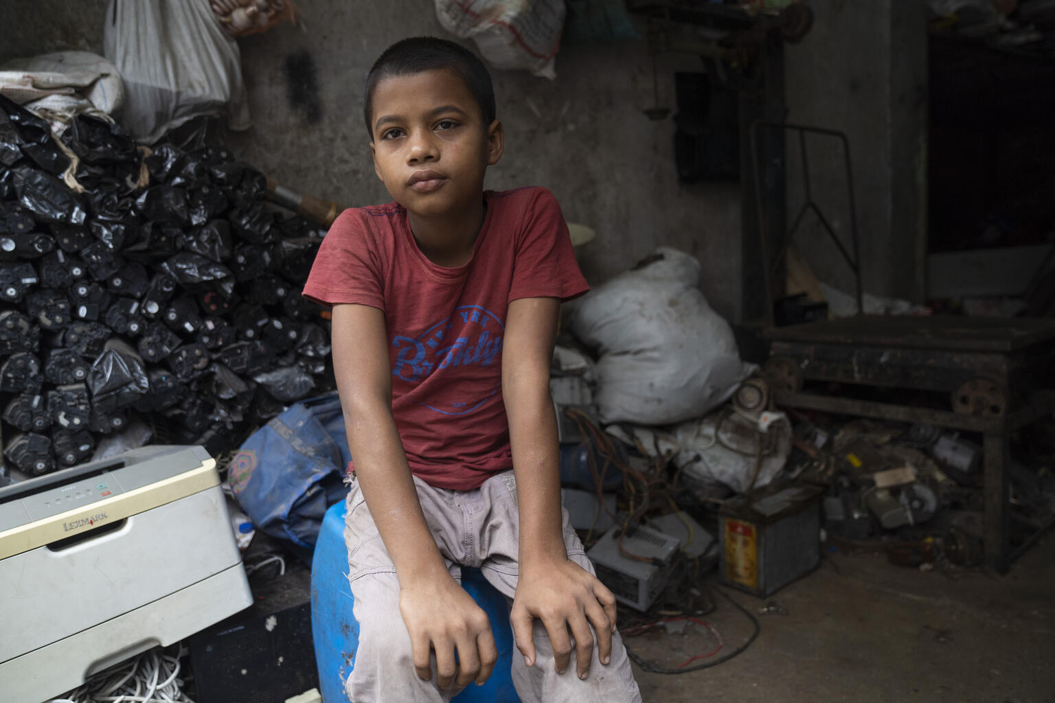 Sabbir child laborer, 10 years old, works in a small E-waste recycling shop in Dhaka.
