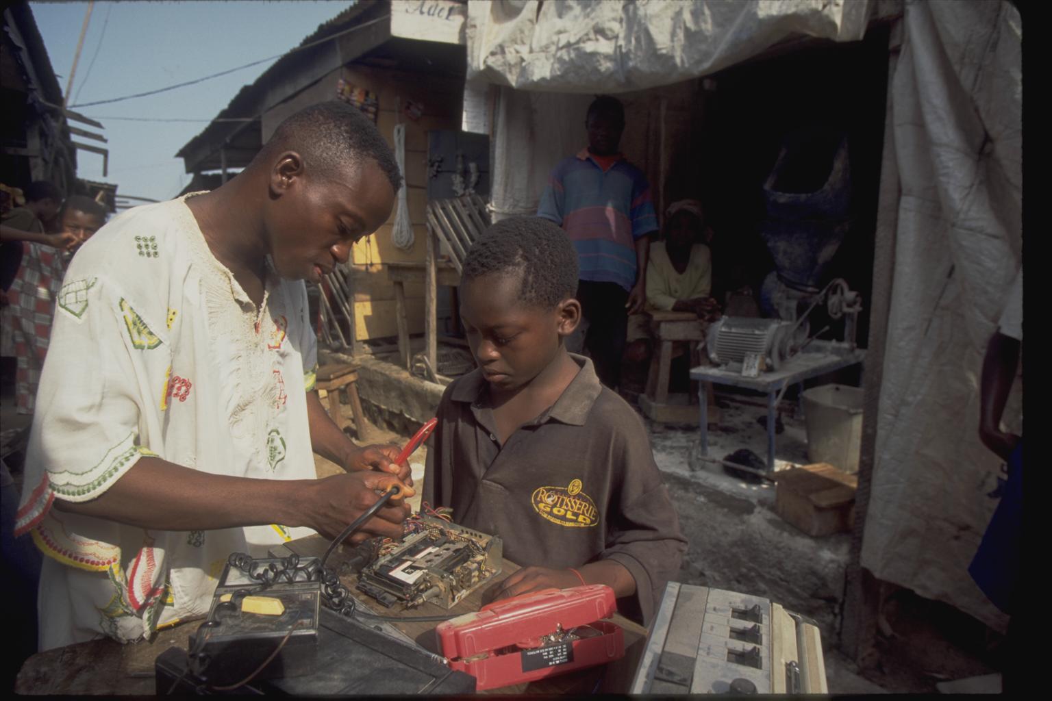 In 1998 in Nigeria, a man teaches Andrew, a 13-year-old boy who lives on the streets, to repair electronics equipment during a workshop at a vocational centre in Ibadan, capital of the south-western state of Oyo.