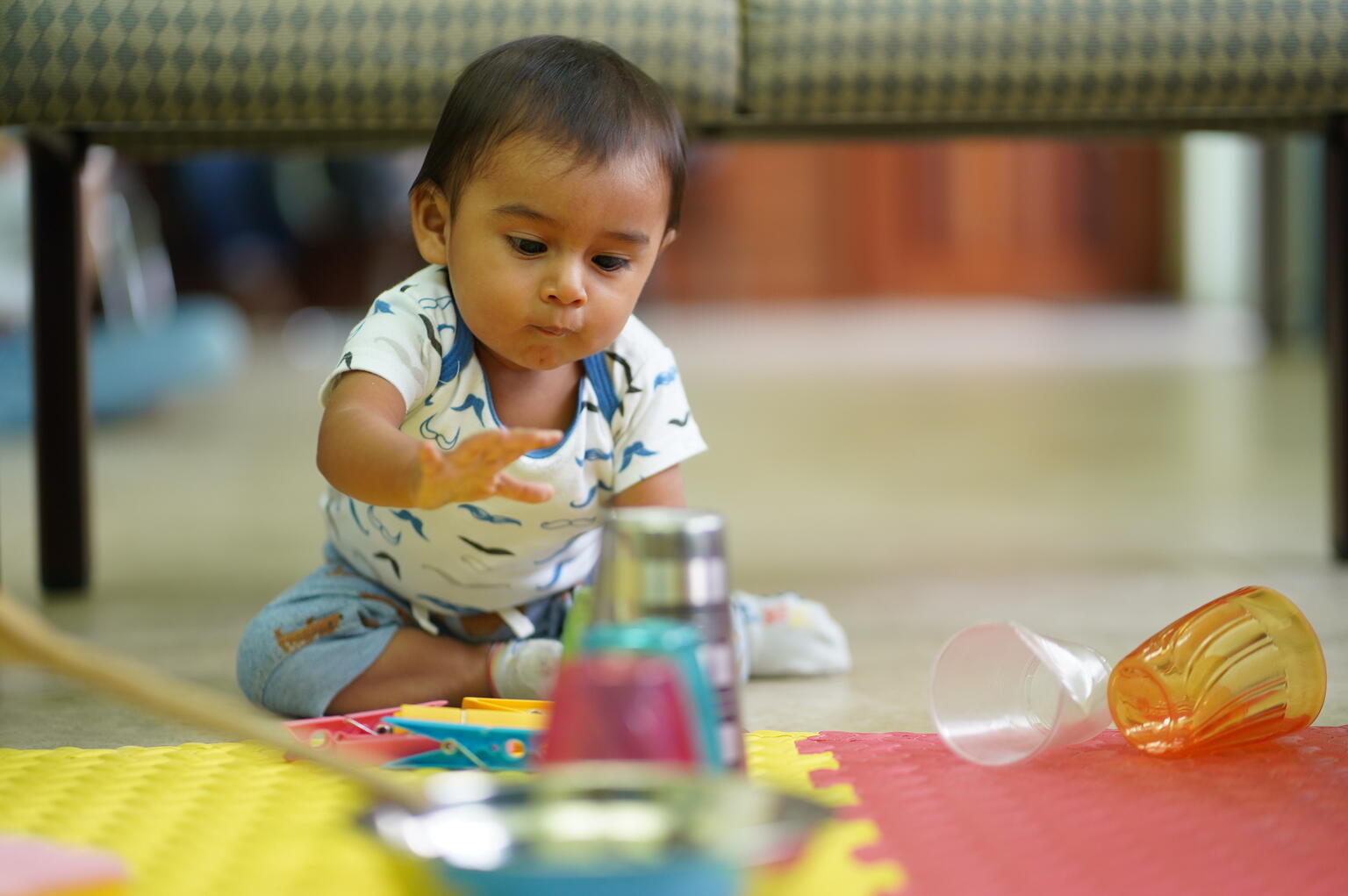 Baby in Belize plays with toys.