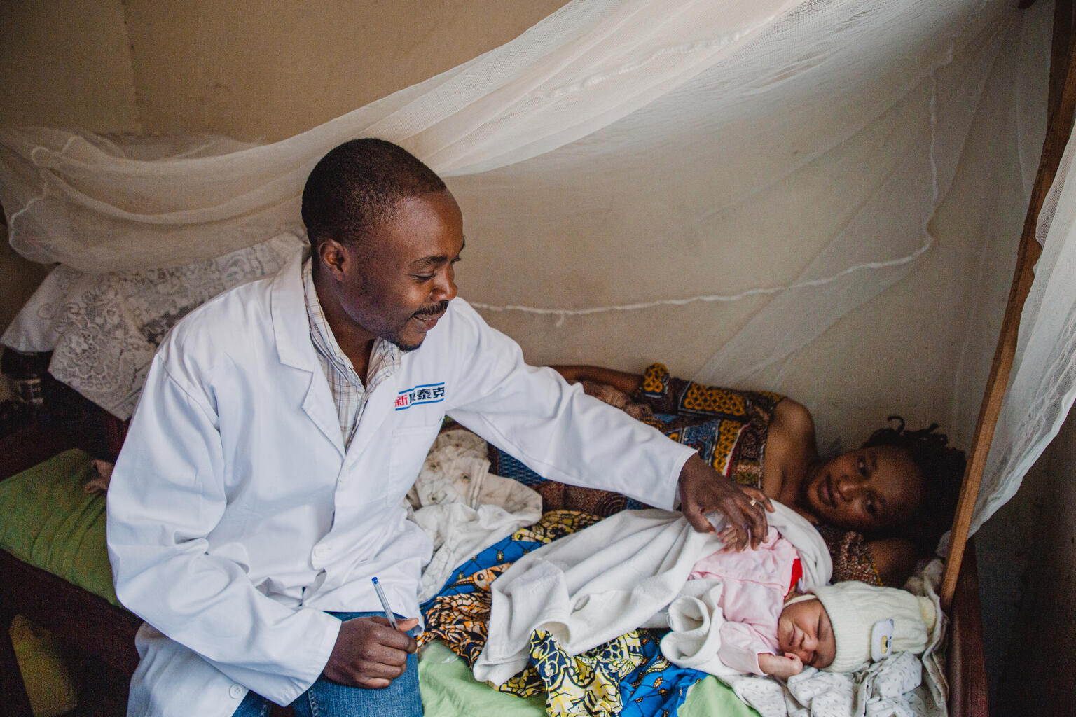 Doctor Nzanzu Kamamwiti checks on a patient at the Tokobika Health Center in Bunia, Ituri Province, DR Congo, January 30, 2022. UNICEF, through AIDES, is implementing a package of interventions to improve access to water, hygiene and sanitation on site. 