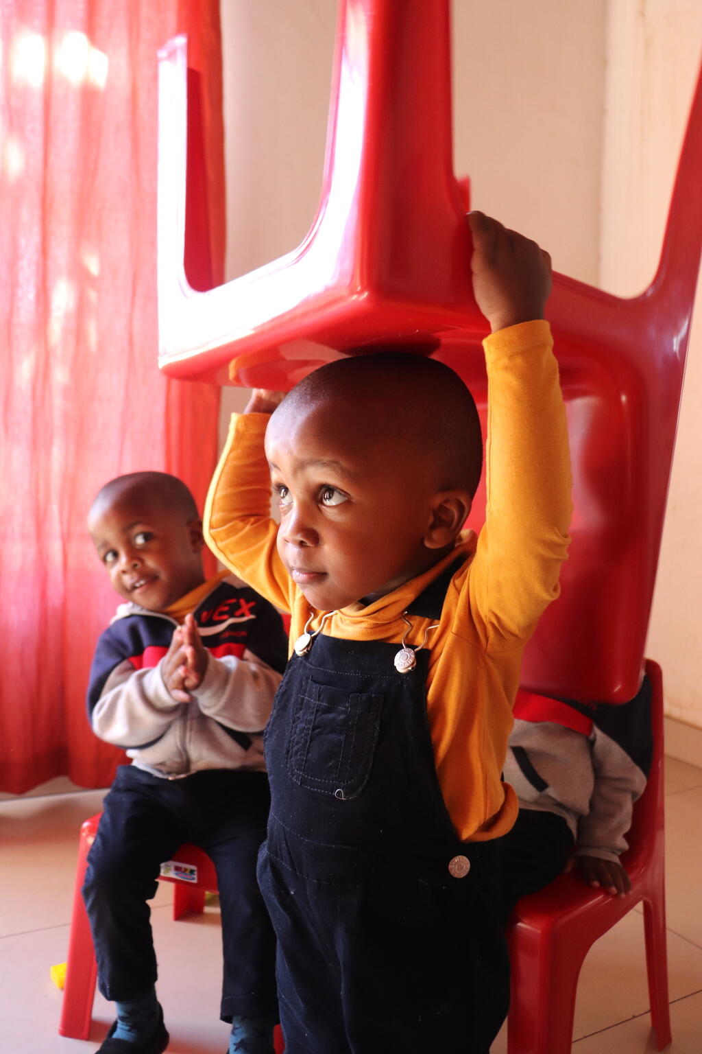 On 18 May 2021, 2-year-old quadruplet Abaleng Jaiden carries a chair on his head while playing with his brothers and parents (not pictured) in the family’s home in Gabarone, Botswana. Mother Keneilwe Ditsile and father Otsile (Ot) Kgafela have seven sons in total. 