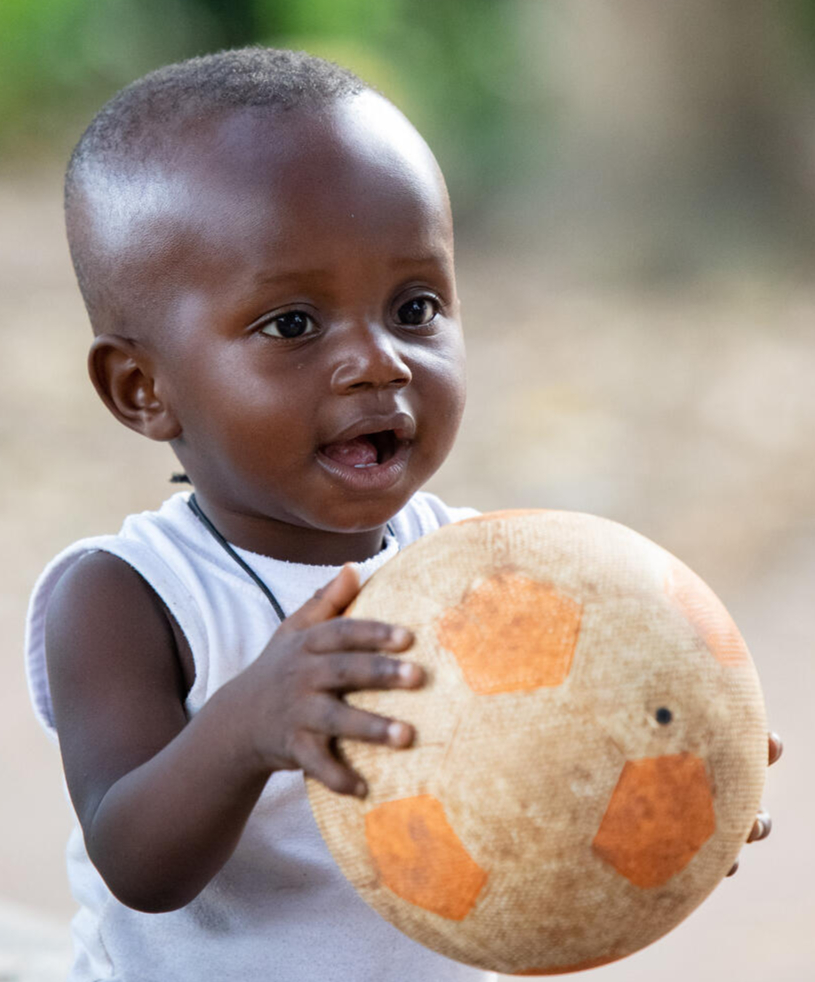 A smiling child playing outside in Yamoussoukro, a city in central Côte d'Ivoire.