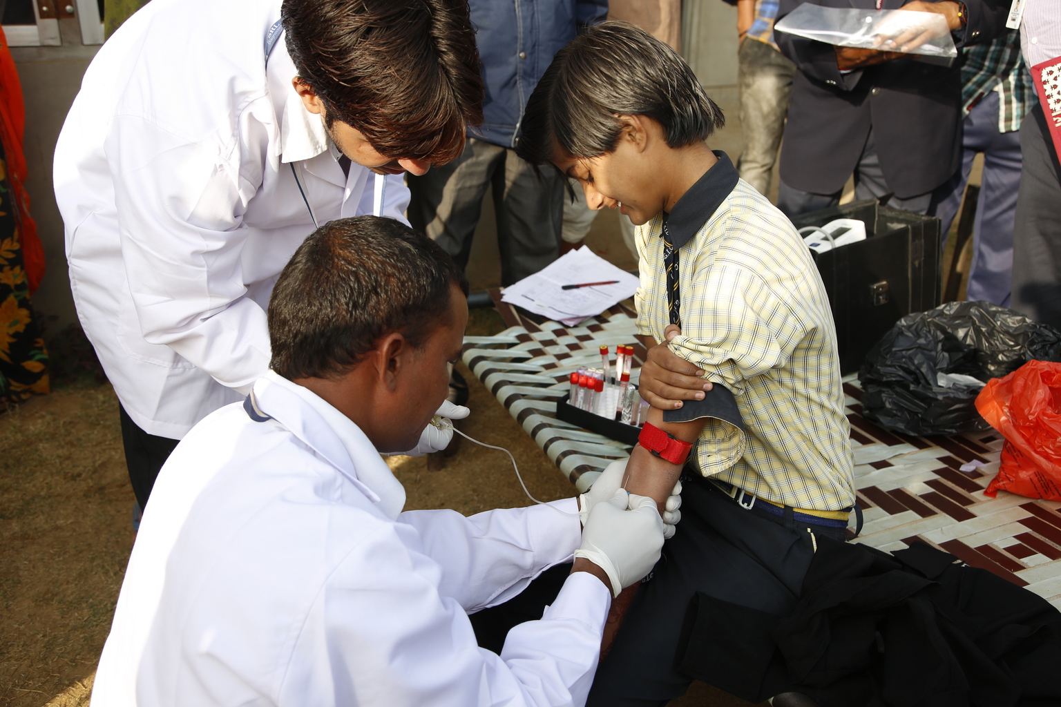 Doctors give a shot to a young boy