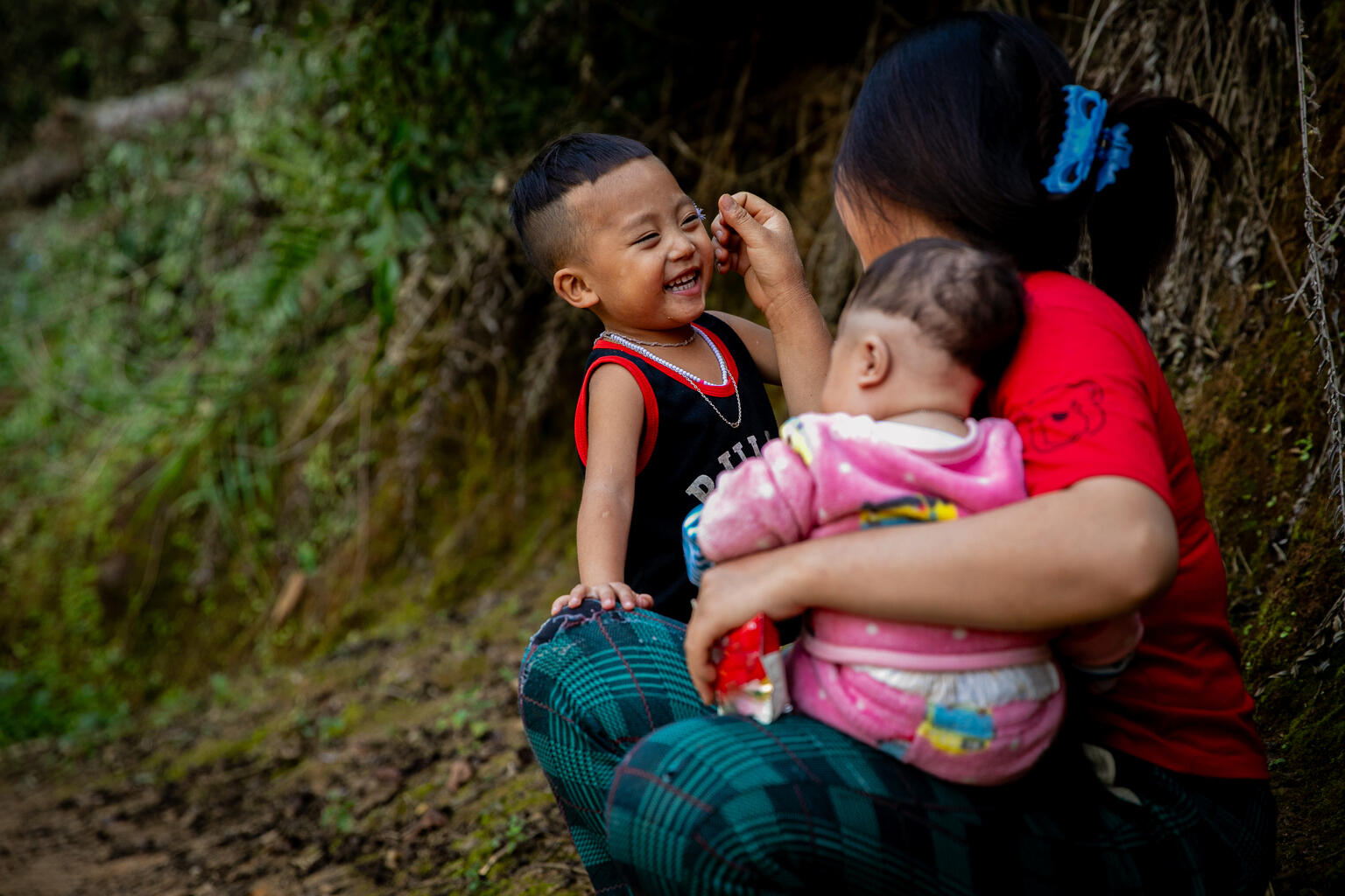  Three-year-old Mùa Tuấn Cường plays with his mother, Sùng Thị Sia, and his three-month-old brother, Mùa A Minh, near their home in Nà Nếnh B Village, Pú Hồng Commune, Điện Biên Đông District, Điện Biên Province.